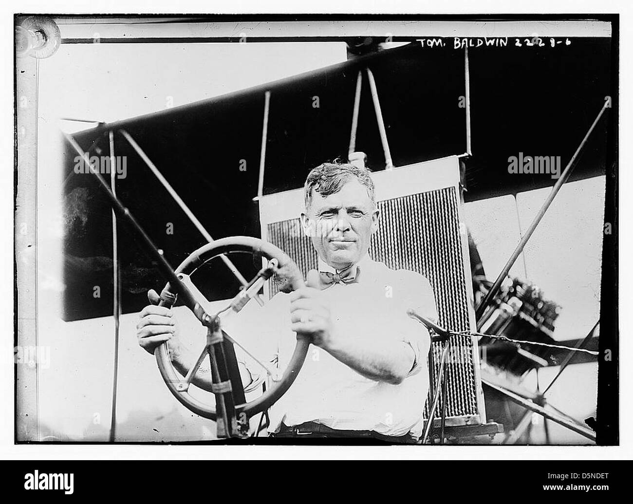 Cette photographie montre Tom Baldwin, un aviateur pionnier, avec son avion Baldwin Red Devil. L'image met en évidence la contribution de Baldwin à l'aviation au début des années 1910, mettant en valeur son avion et sa tenue de vol vintage. Banque D'Images