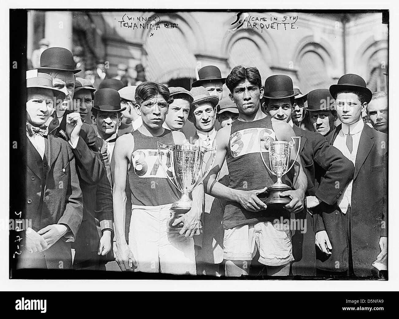 Cette photo historique capture Lewis Tewanima, un athlète indien Hopi, célébrant sa victoire à la première place, tandis que Mitchell Arquette est représenté à la cinquième place. La photo souligne leurs réalisations lors d'une cérémonie de remise des prix. Banque D'Images