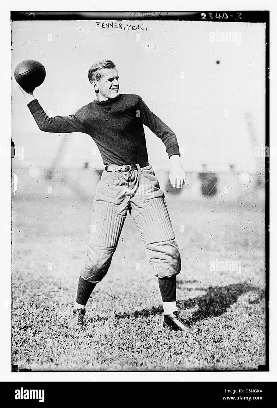 Une photographie des années 1910 montrant Fenner, un footballeur de Pennsylvanie, en action pendant un match. L'image montre le joueur portant un équipement de football rembourré, y compris des épaulettes, et se préparant à lancer une passe vers l'avant. Banque D'Images