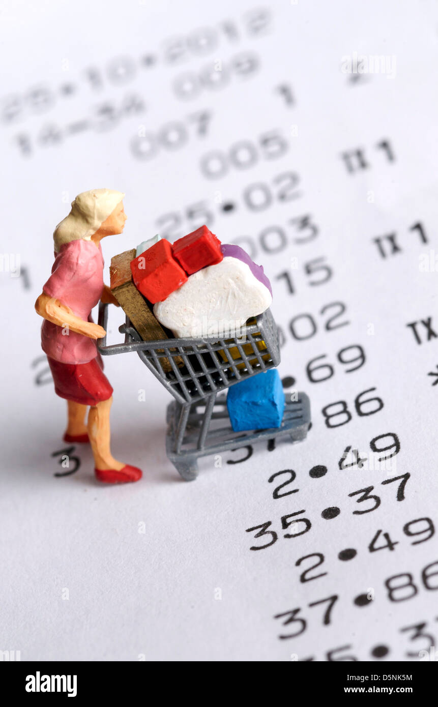 Figurine miniature d'une femme avec un panier sur un reçu - Projets / shopping concept Banque D'Images
