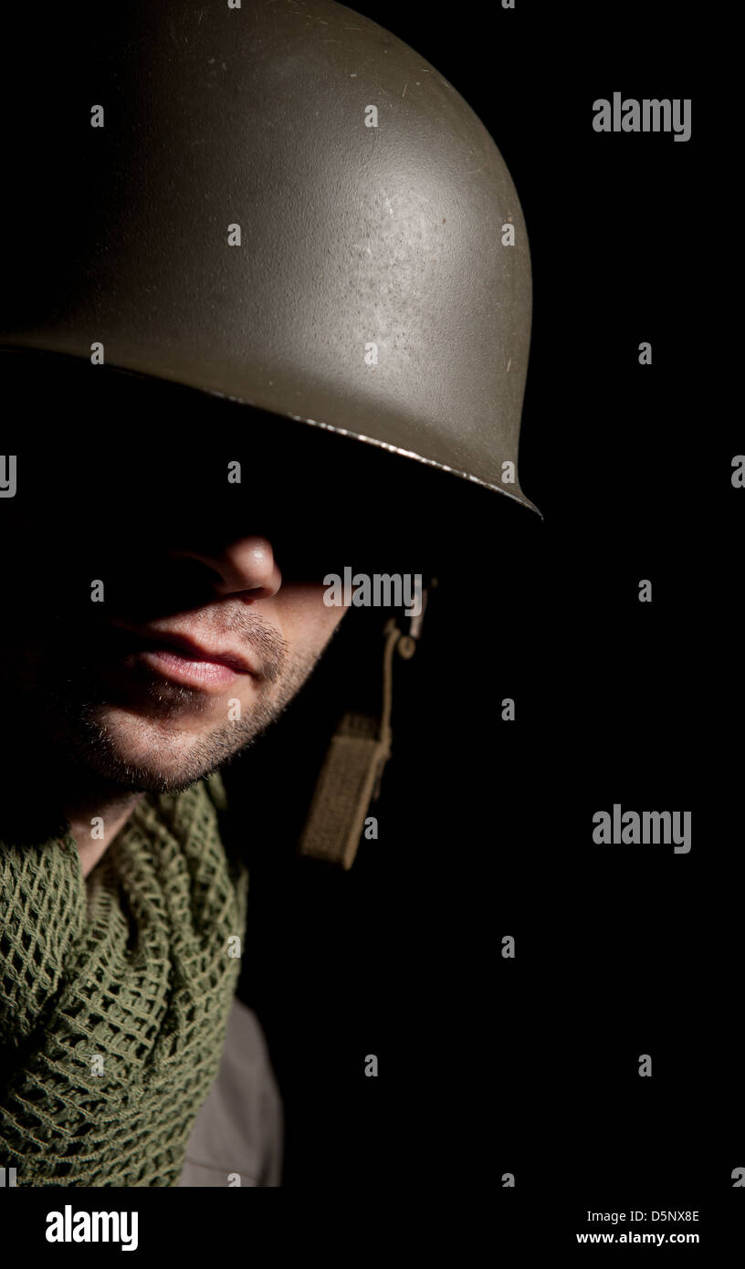 Portrait d'un WW2 soldat américain dans l'ombre profonde d'un fond noir. Banque D'Images