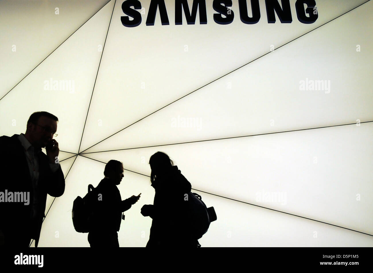 Ombre silhouette de clients balade à côté du stand Samsung au World Mobile Congress de Barcelone 2013. 270213. Banque D'Images