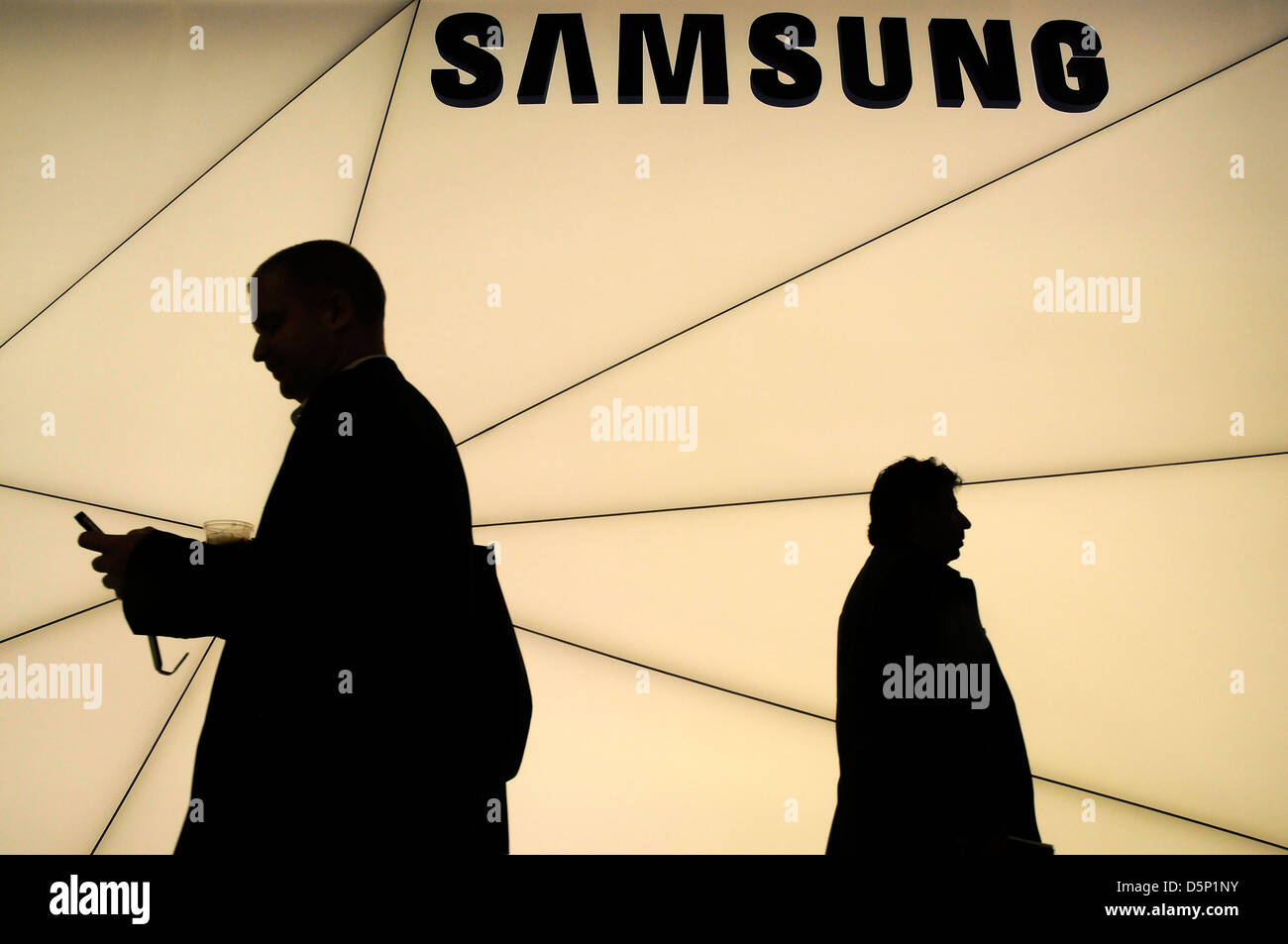 Ombre silhouette de clients balade à côté du stand Samsung au World Mobile Congress de Barcelone 2013. 270213. Banque D'Images