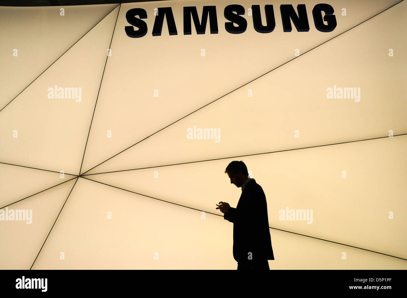 Ombre silhouette de clients balade à côté du stand Samsung au World Mobile Congress de Barcelone 2013. 270213. Banque D'Images