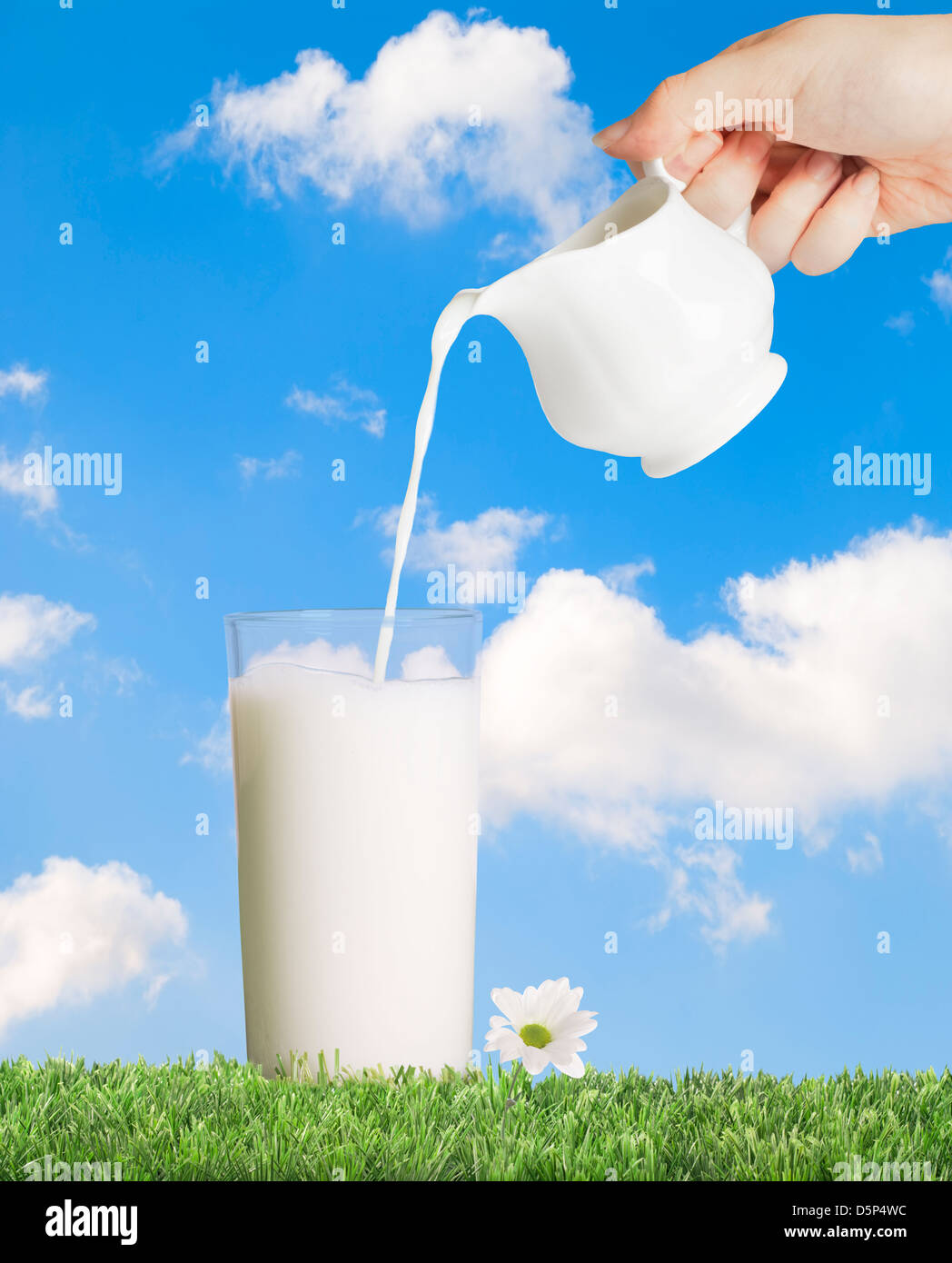 Verser la crème complète dans un verre de lait Banque D'Images