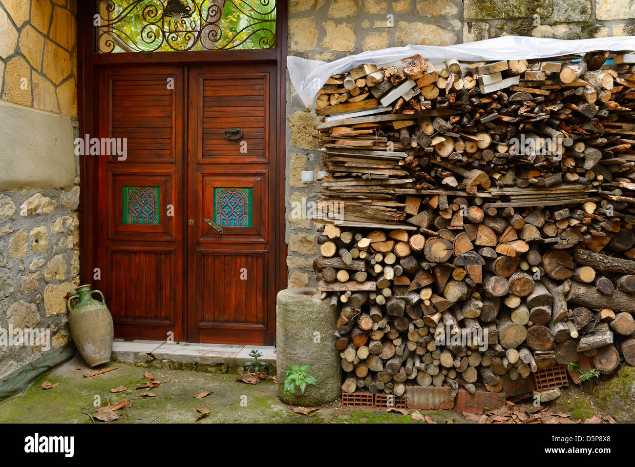 Porte ouvragée avec pile de bois dans l'ancien village sur une colline de Yesilyurt Malatya Turquie Banque D'Images