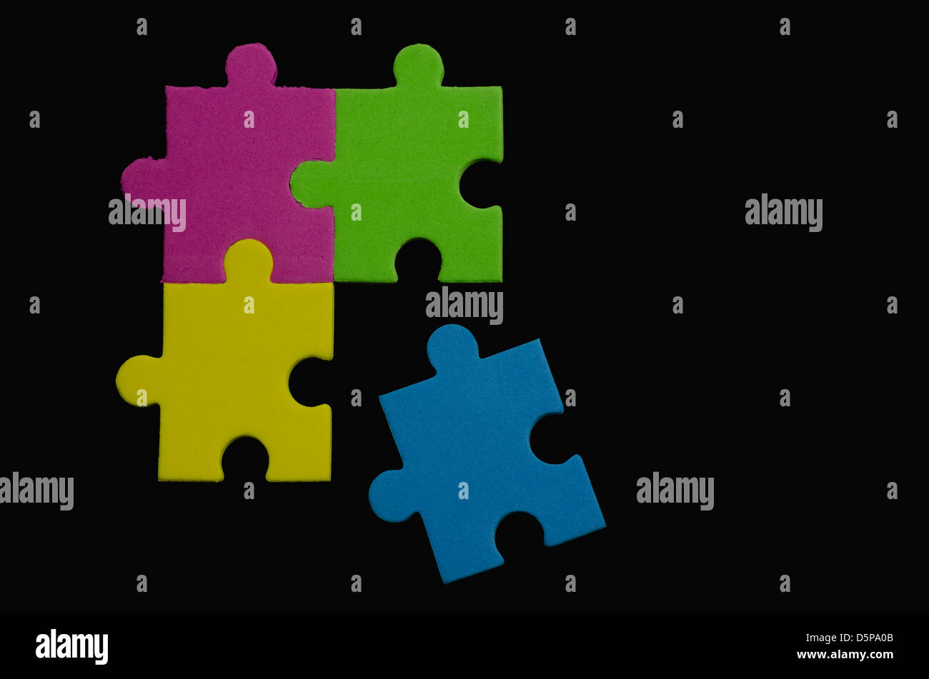 Pièces de puzzle colorées sur fond noir représentant la diversité et la tolérance Banque D'Images