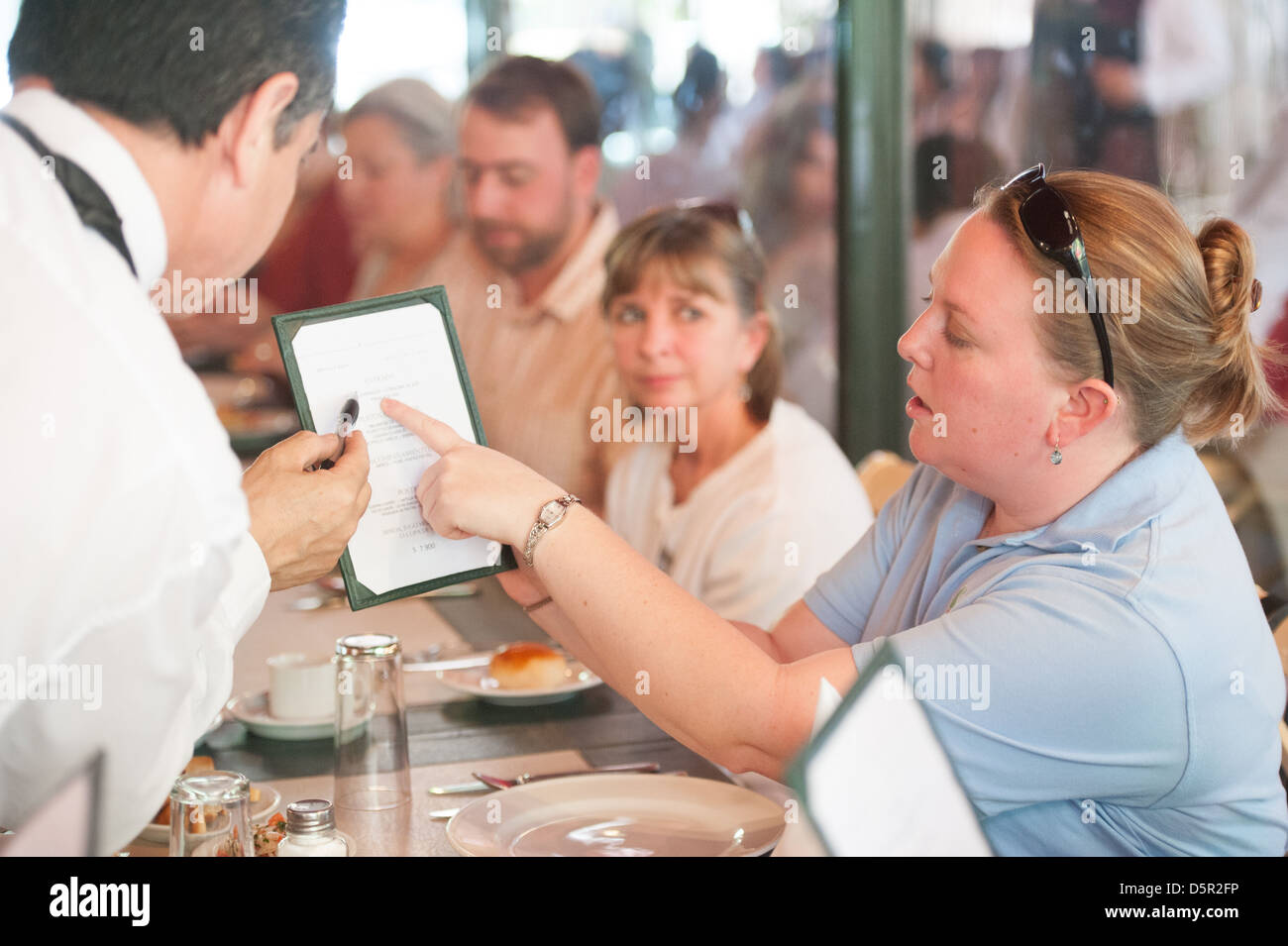 La traduction d'un serveur pour une femme menu de dîner dans un restaurant à Santiago du Chili Banque D'Images
