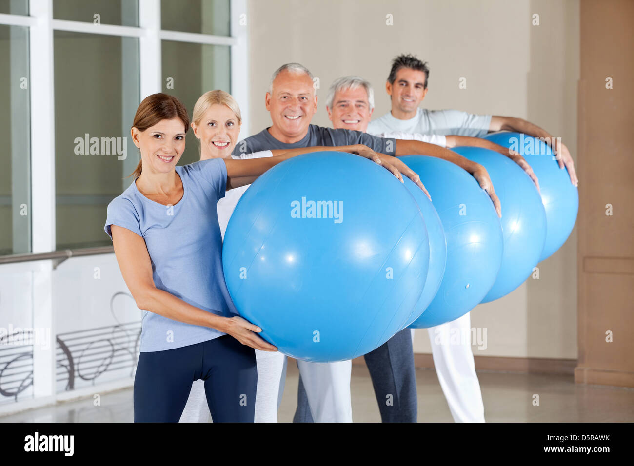 L'exécution de dirigeants du groupe blue fitness balls en centre de remise en forme Banque D'Images