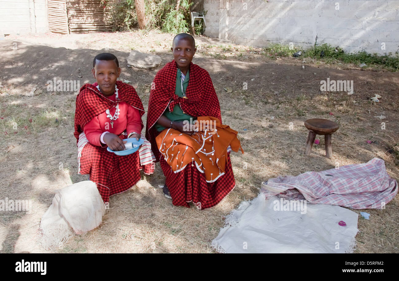 L'Afrique, Tanzanie;Maasai women en costume traditionnel avec des bijoux faits main assis dans la cour de leur village Banque D'Images