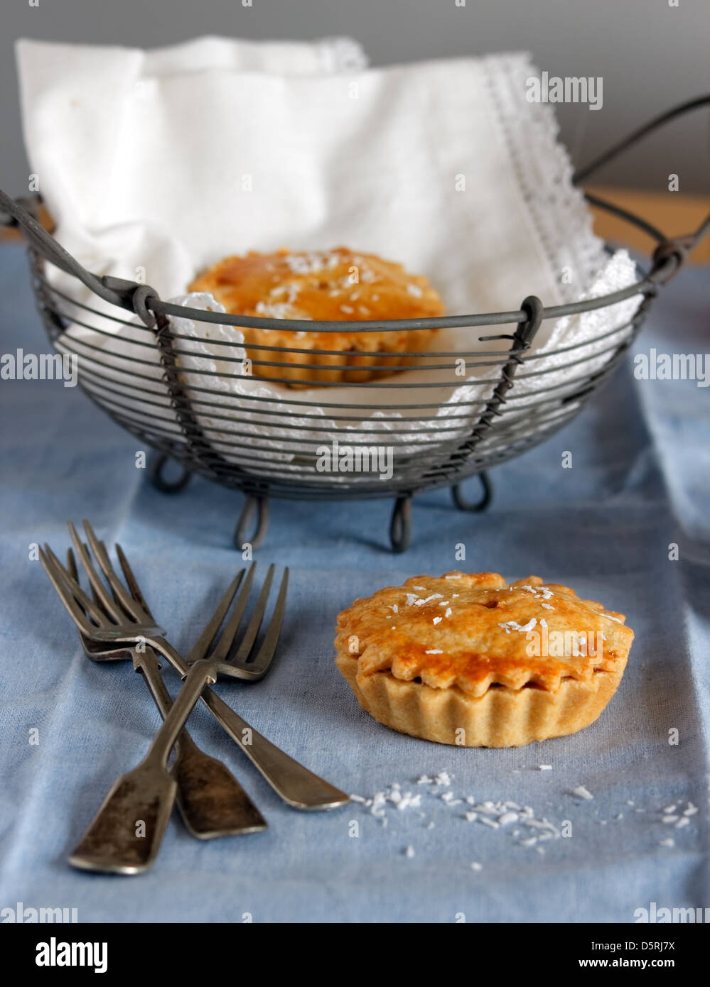 Tarte aux fruits avec de la vaisselle avec un panier de tartelettes en arrière-plan. Banque D'Images