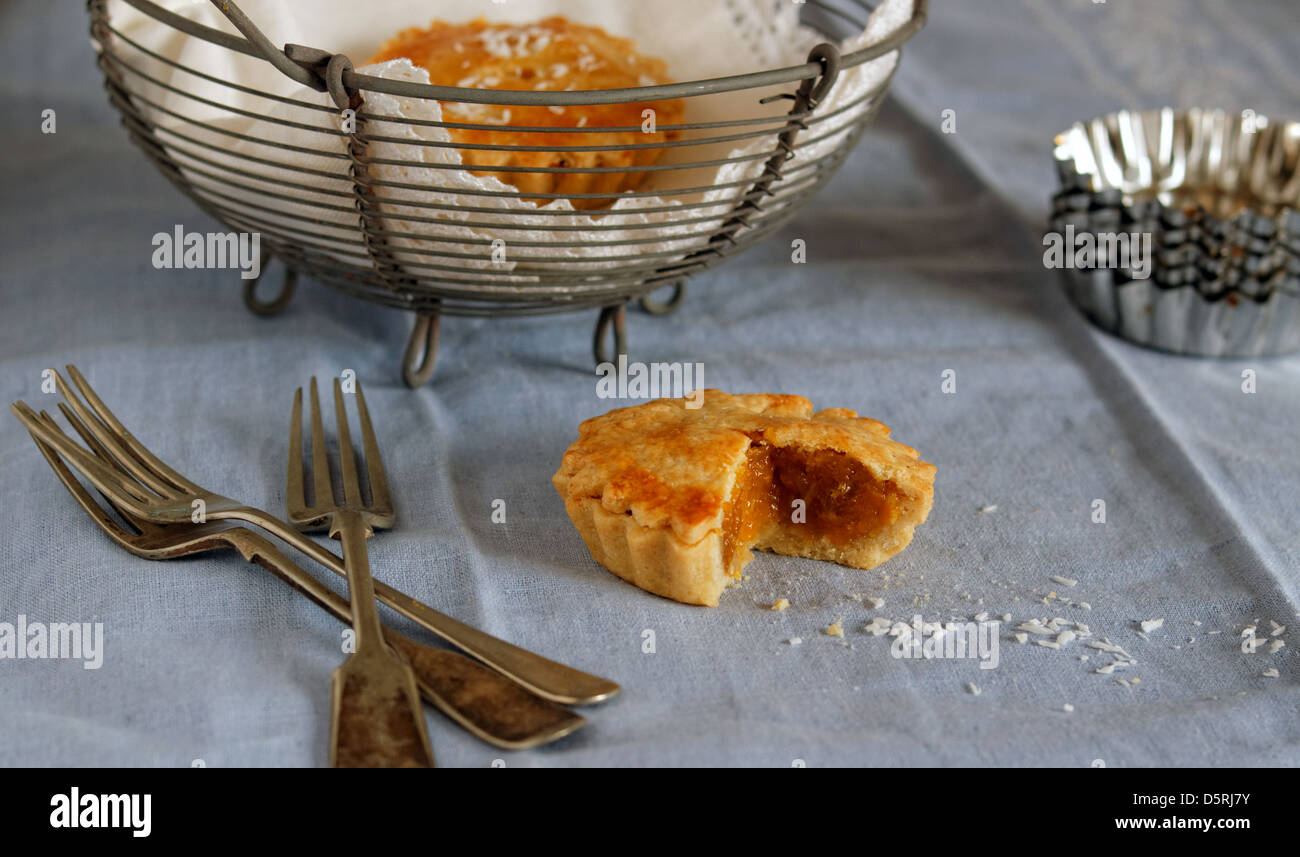 Tarte aux fruits avec de la vaisselle avec un panier de tartelettes en arrière-plan. Banque D'Images