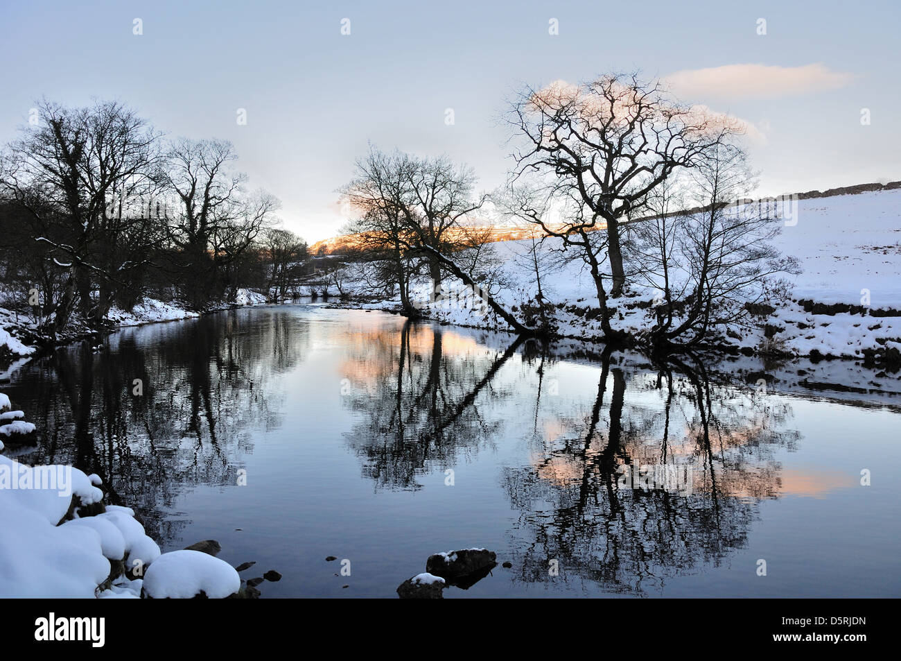 Rivière Wharfe soir près de Hebden North Yorkshire Angleterre, dans la neige. Reflets dans la rivière. Banque D'Images