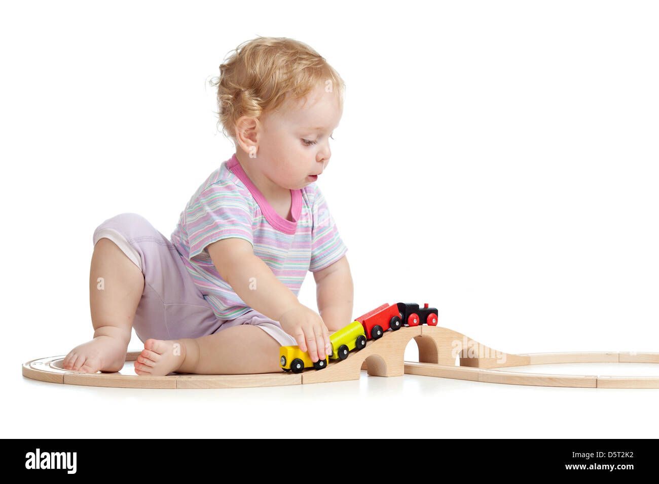 Cute child joue avec train en bois isolé sur blanc Banque D'Images