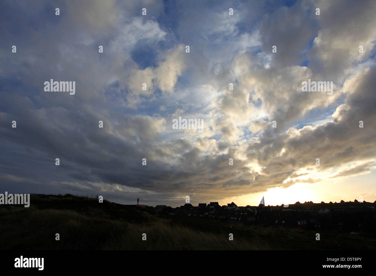 Saint Thomas l'Église et le phare du village Hoernum silhouettes contre le soleil mourant sur l'île de Sylt, Allemagne, 18 novembre 2012. Photo : HEIKO LOSSIE Banque D'Images