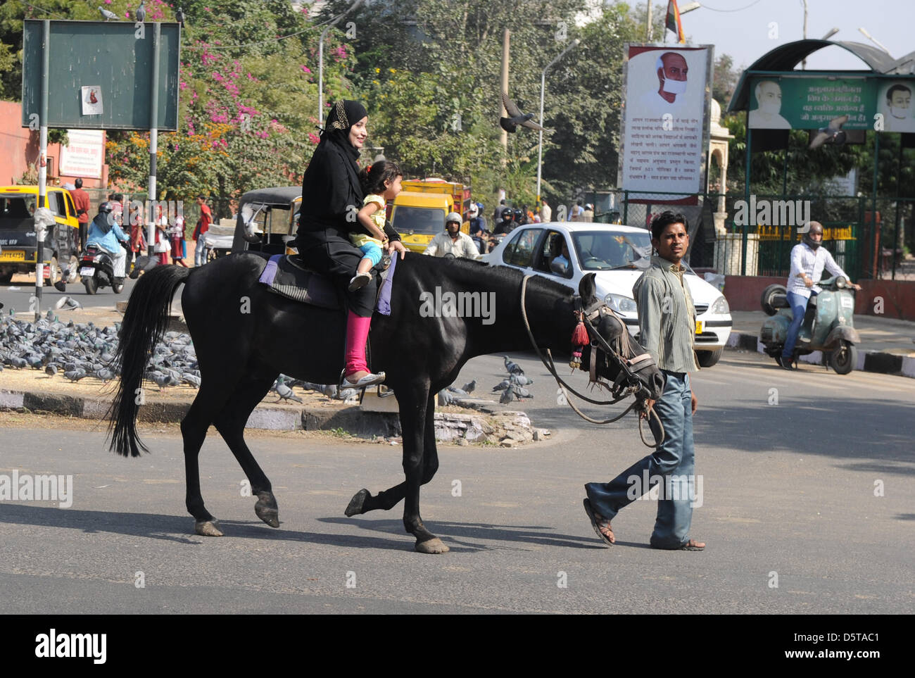 Les guides d'un homme une femme et son enfant sur un cheval à travers le trafic dans Jaipur, Inde, 16 novembre 2012. Photo : Jens Kalaene Banque D'Images