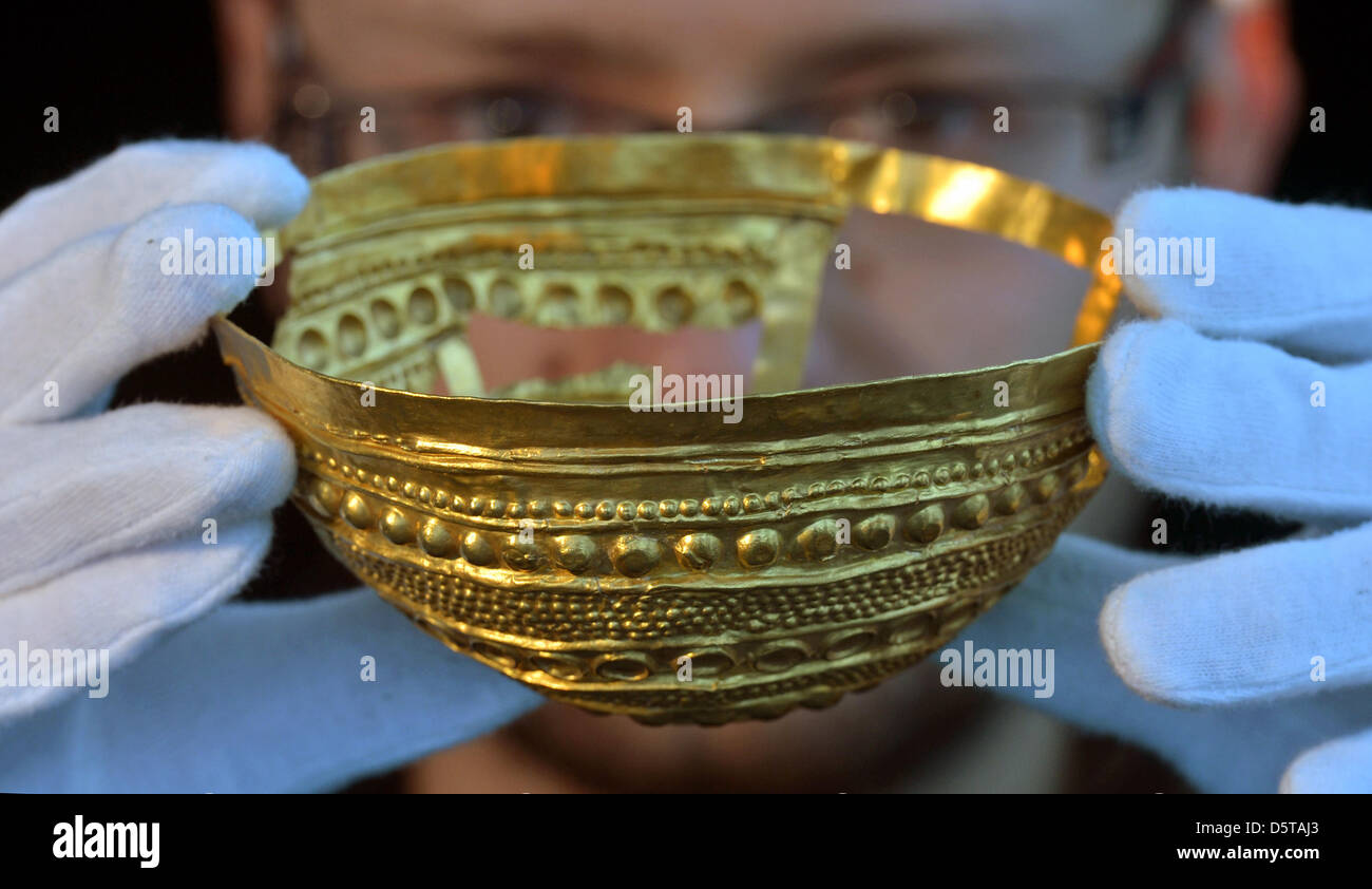 L'année 3300 un vieux golden bowl est présenté par l'archéologue Marek Vercik au Musée de l'état de l'histoire ancienne, à Halle, Allemagne, 2 novembre 2012. Le bol est décoré avec des symboles du culte de l'âge du bronze et a été un objet-culte des prêtres. Il sera exposé dans le cadre du prolongement de l'exposition permanente sur le milieu et fin de l'âge du bronze et l'âge du fer à compter du 7 décembre Banque D'Images