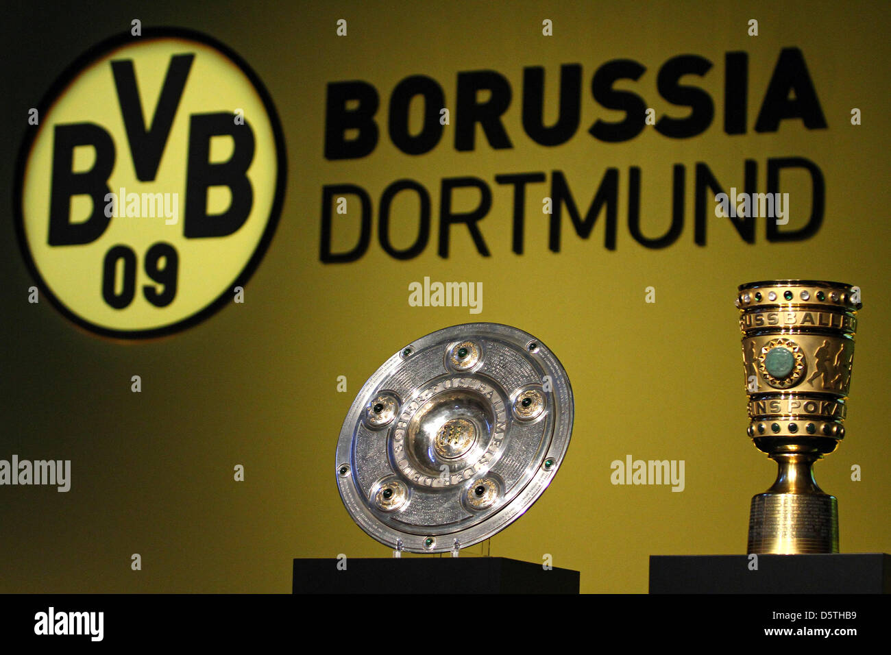 Le trophée du championnat de Bundesliga (L) et de la coupe d'Allemagne sont  mis en place en face du club logo du Borussia Dortmund à l'Assemblée  générale à la Westfalenhalle à Dortmund,