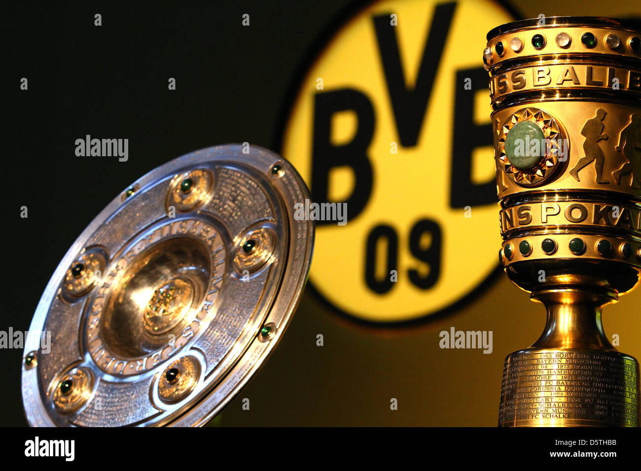 Le trophée du championnat de Bundesliga (L) et de la coupe d'Allemagne sont  mis en place en face du club logo du Borussia Dortmund à l'Assemblée  générale à la Westfalenhalle à Dortmund,