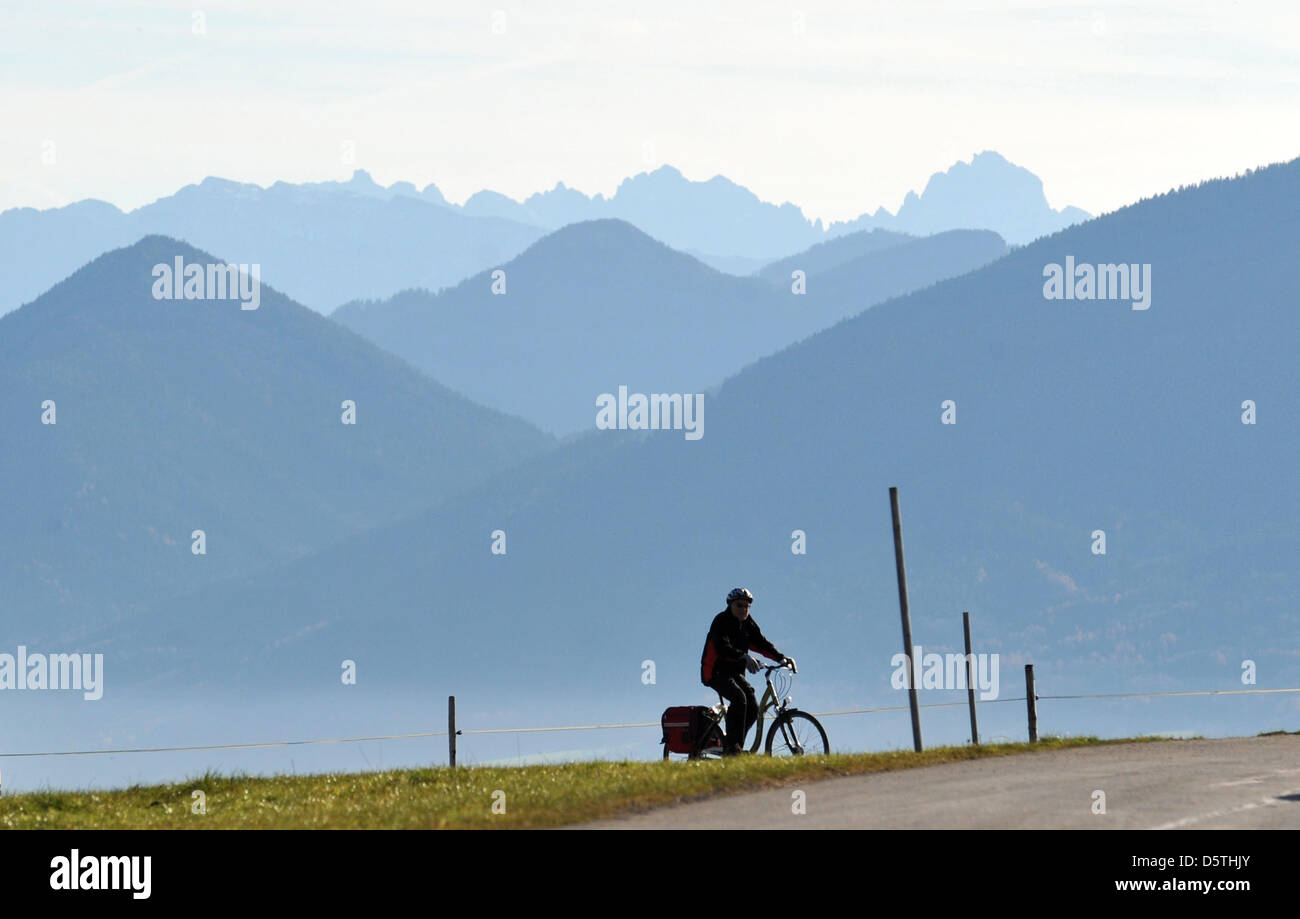Un homme chevauche son vélo en face de l'Alpes ensoleillées sur Bamberg, Allemagne, 25 Novelber 2012. Photo : Andreas Gebert Banque D'Images