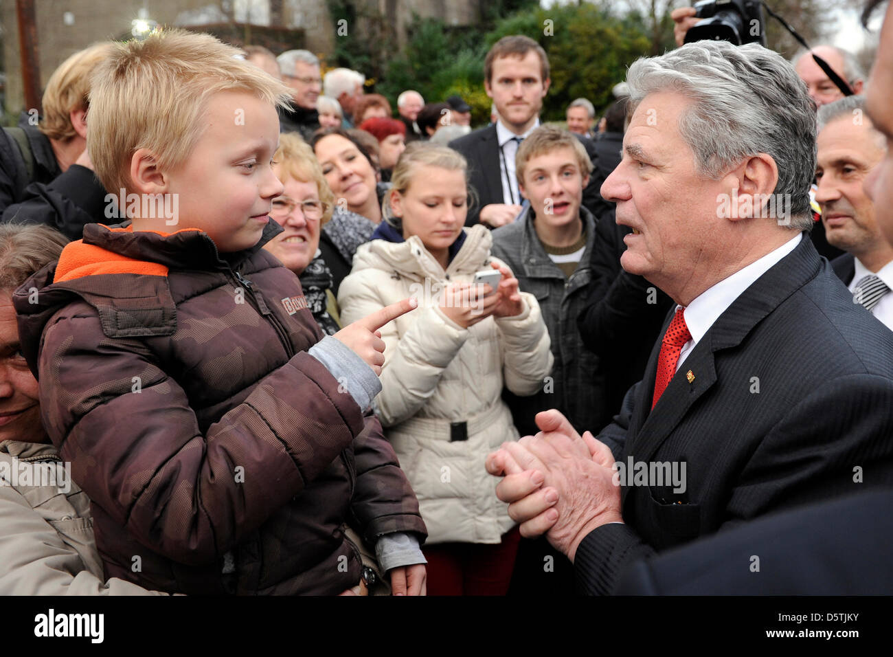 Le président fédéral allemand Joachim Gauck (r) parle à un petit garçon lors de sa première visite à l'état de Rhénanie du Nord-Westphalie à Bottrop, Allemagne, 26 novembre 2012. Photo : Marius Becker Banque D'Images