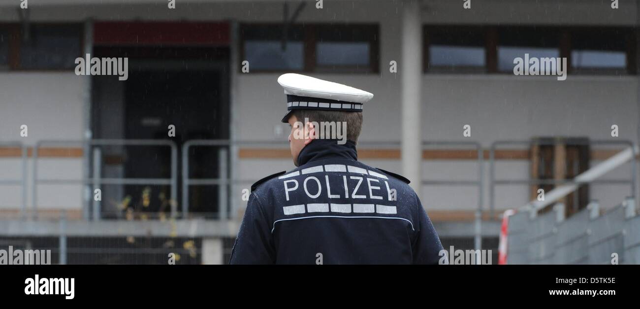 Un agent de police se place en avant d'un atelier pour les personnes handicapées à Titisee-Neustadt, Allemagne, 27 novembre 2012. 14 personnes ont été tuées le 26 novembre lorsqu'un incendie s'est propagé à travers l'atelier. Photo : PATRICK SEEGER Banque D'Images