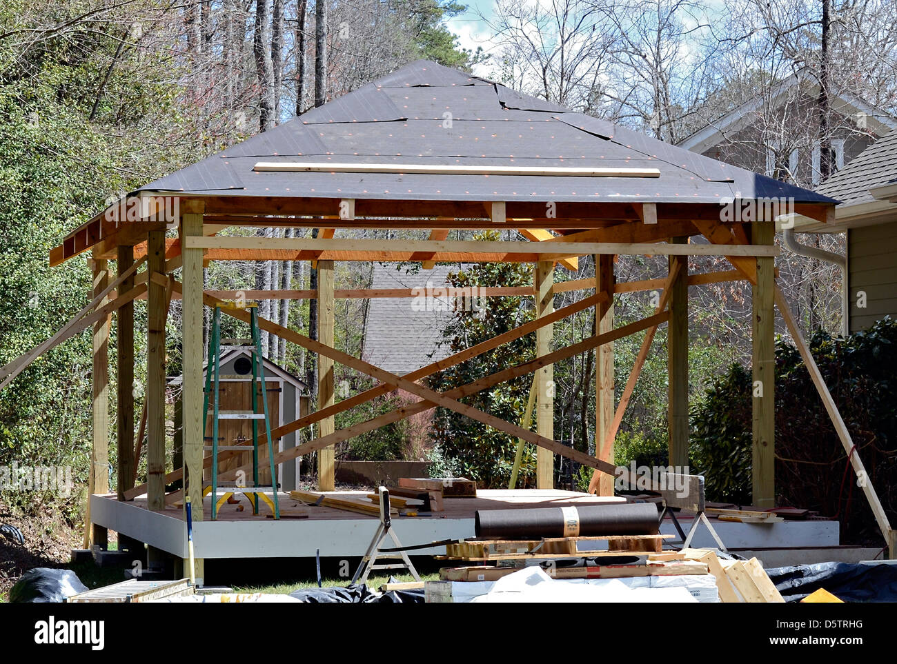 La construction d'une terrasse de bois couverte salon à l'arrière d'une maison existante. Le parquet est un matériau composite. Banque D'Images
