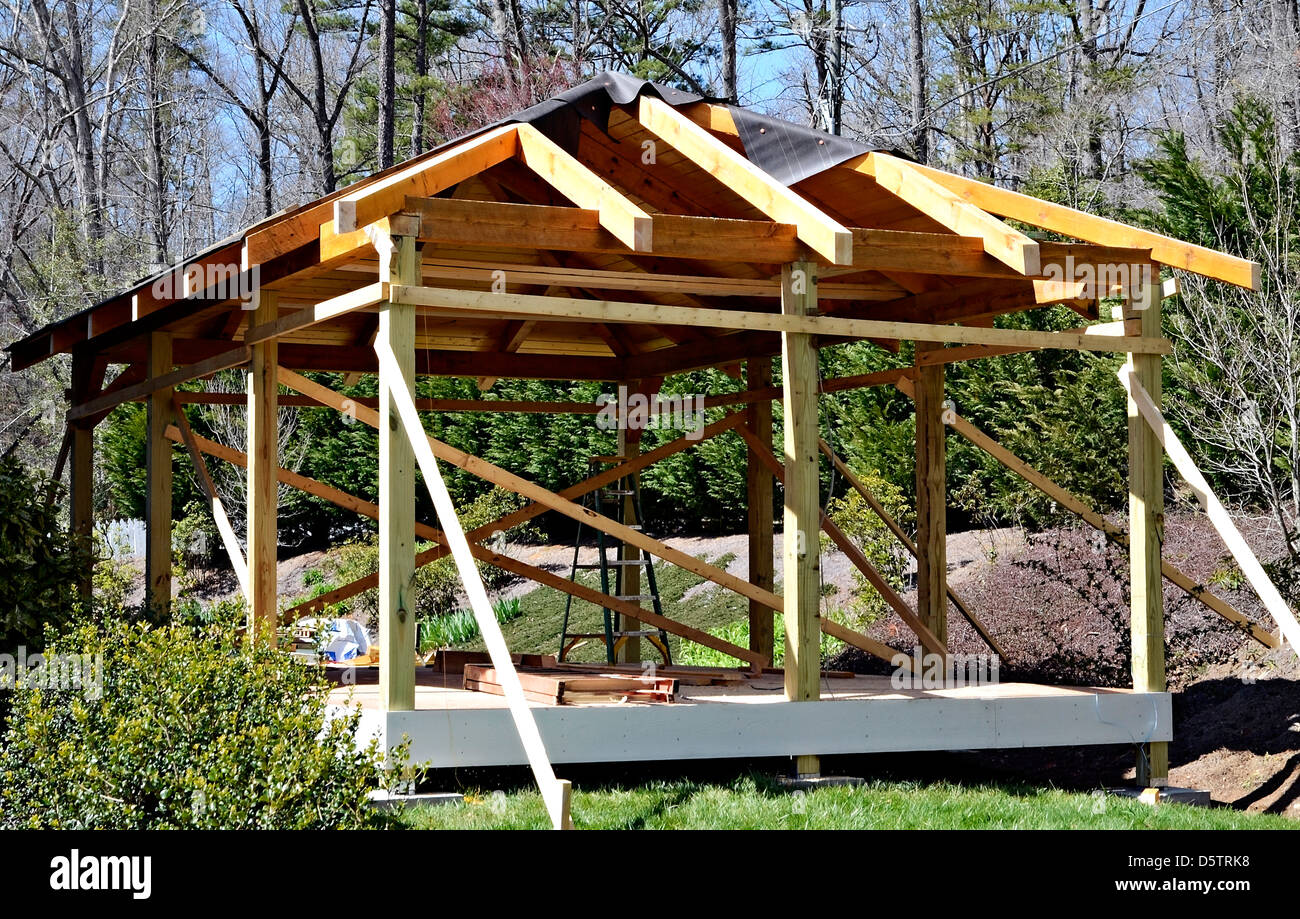La construction d'une terrasse de bois couverte salon à l'arrière d'une maison existante. Le parquet est un matériau composite. Banque D'Images