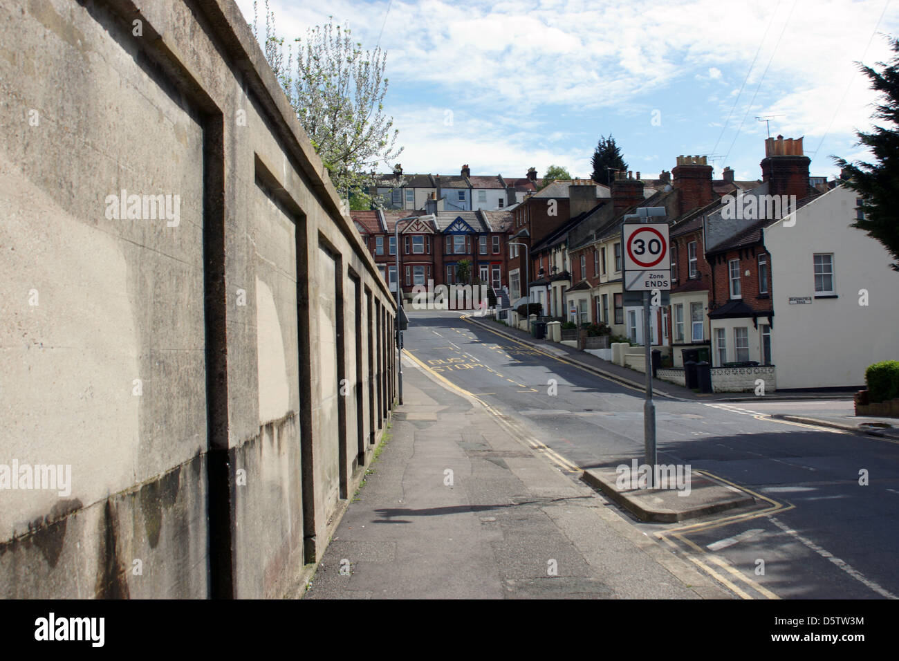 Pavé de la rue Hastings signe l'arrêt de bus Vitesse limite mur aperçu Banque D'Images