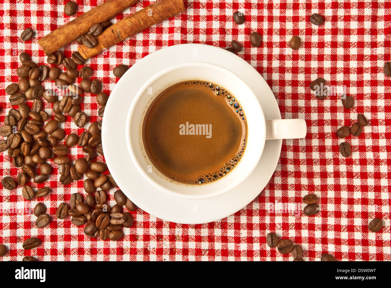 Tasse de café avec des bâtons de cannelle et les grains de café sur la table. Banque D'Images