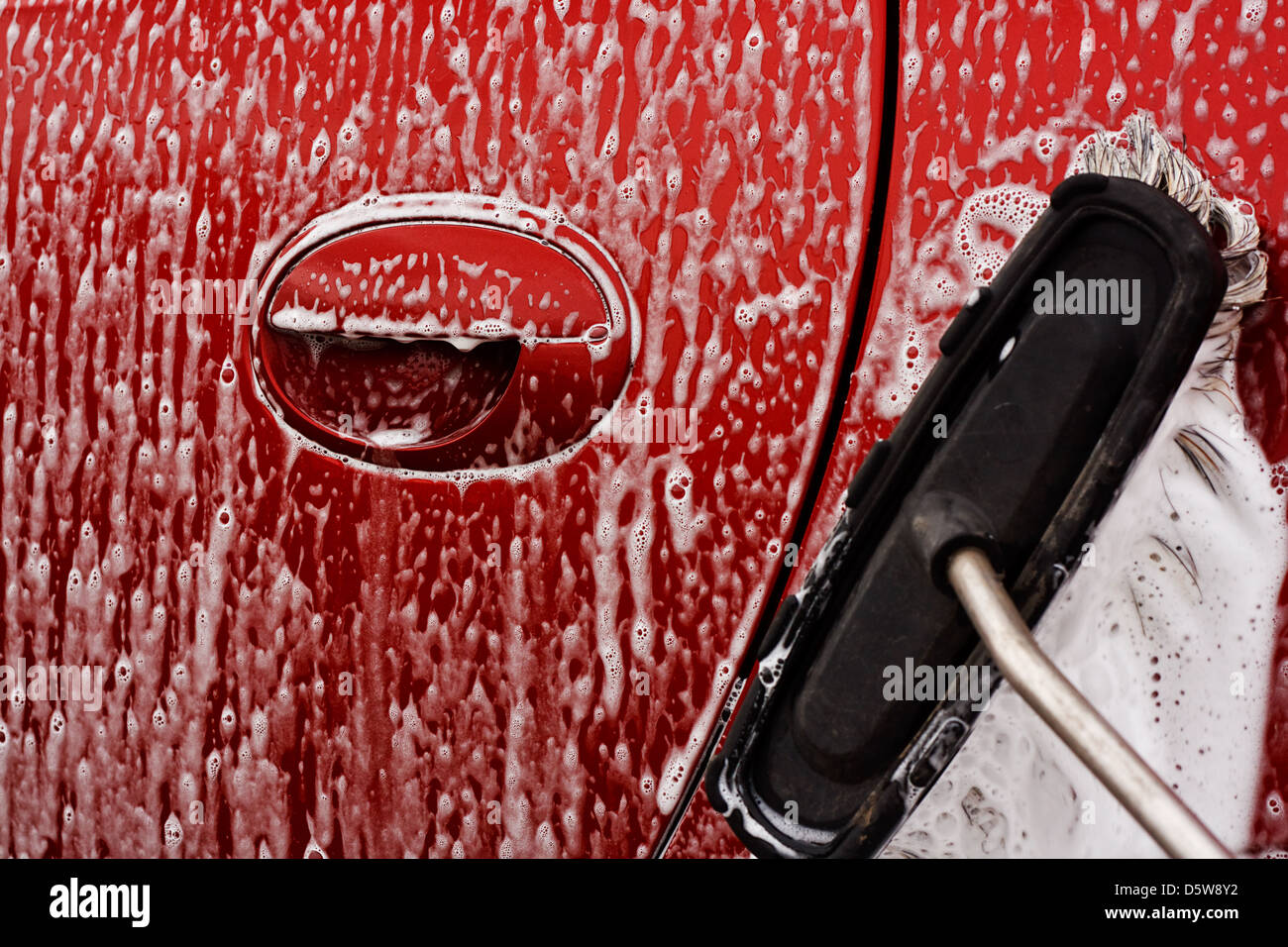 Laver la voiture avec savonneux brosse douce à un lavage de voiture Banque D'Images
