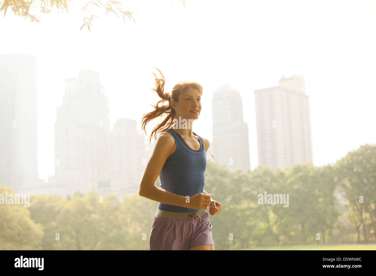 Woman running in urban park Banque D'Images