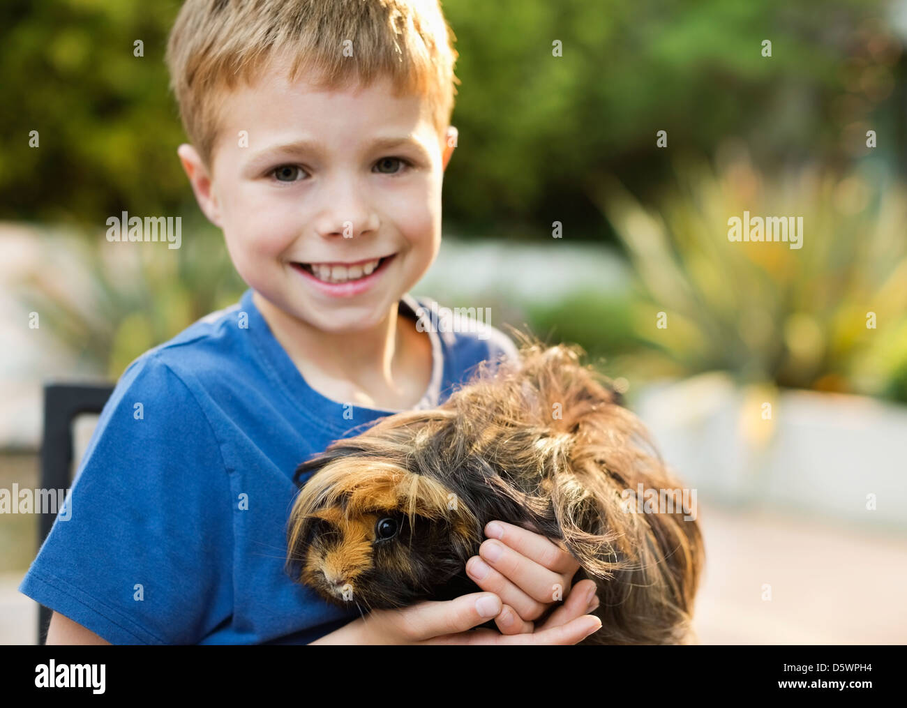 Smiling boy holding cochon d'extérieur Banque D'Images