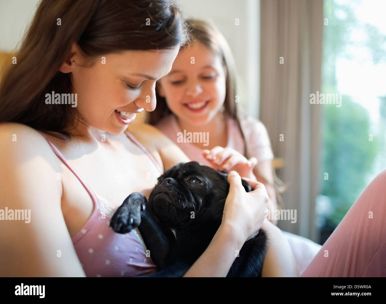 Mère et fille petting dog in bed Banque D'Images