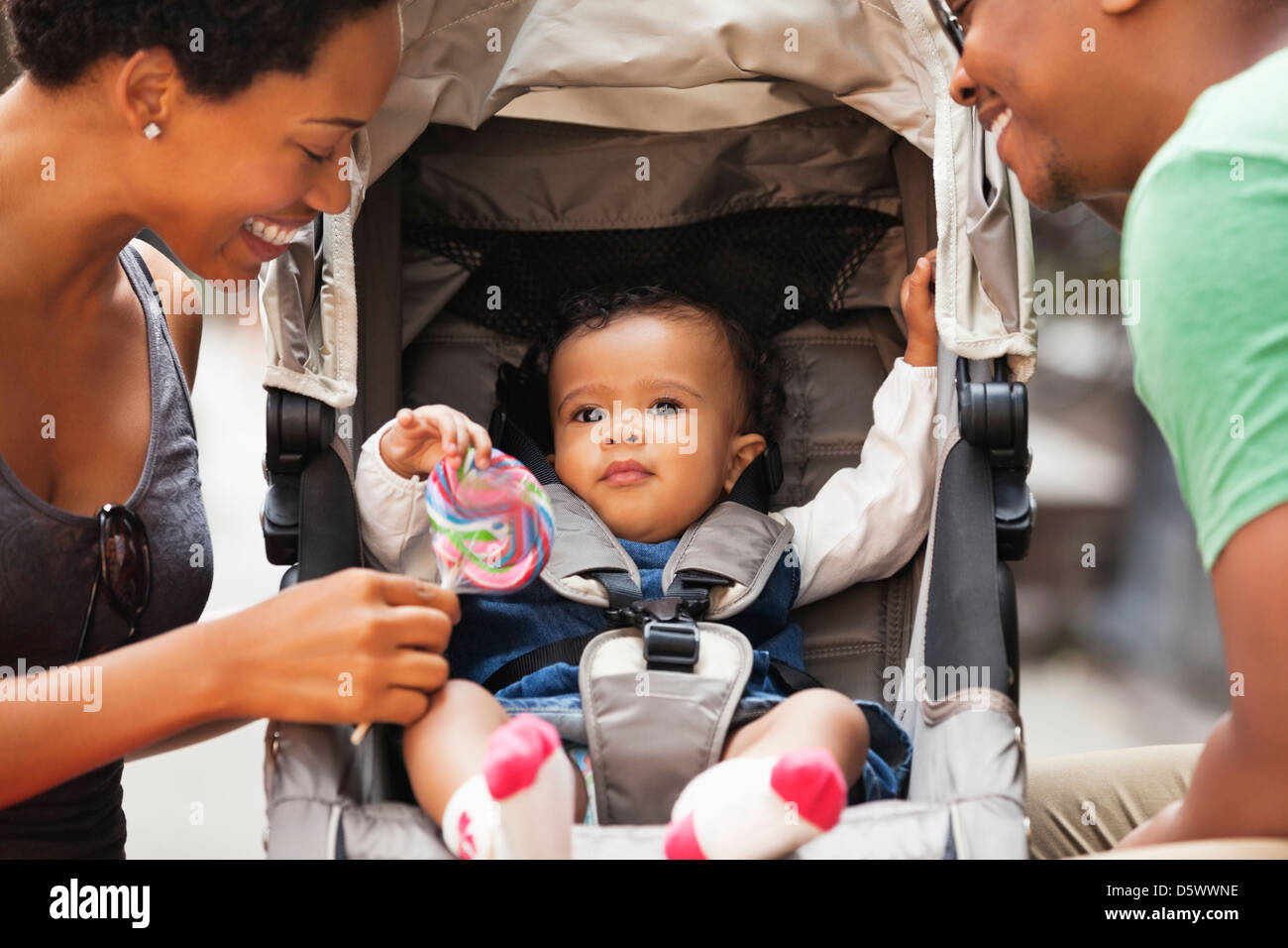 Parents en parler au bébé dans la poussette on city street Banque D'Images