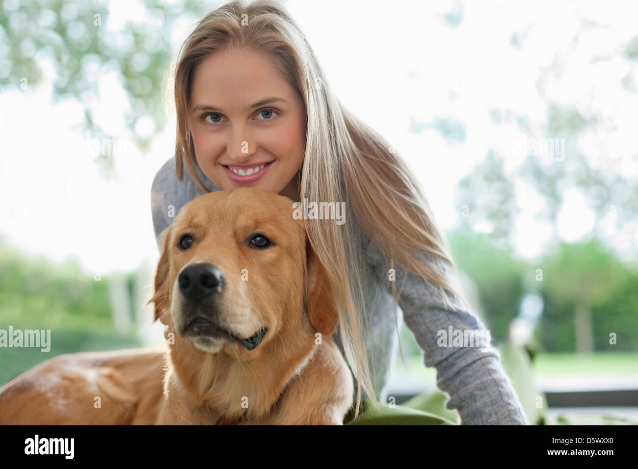 Woman relaxing with dog indoors Banque D'Images
