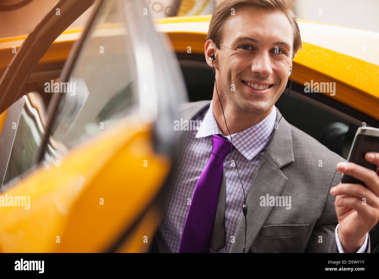 Businessman climbing out of taxi Banque D'Images