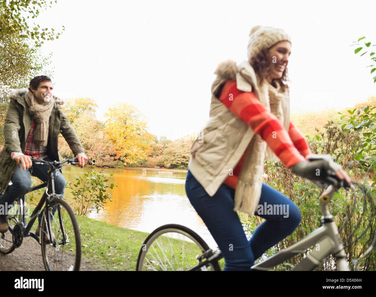 Couple riding bicycles in park Banque D'Images