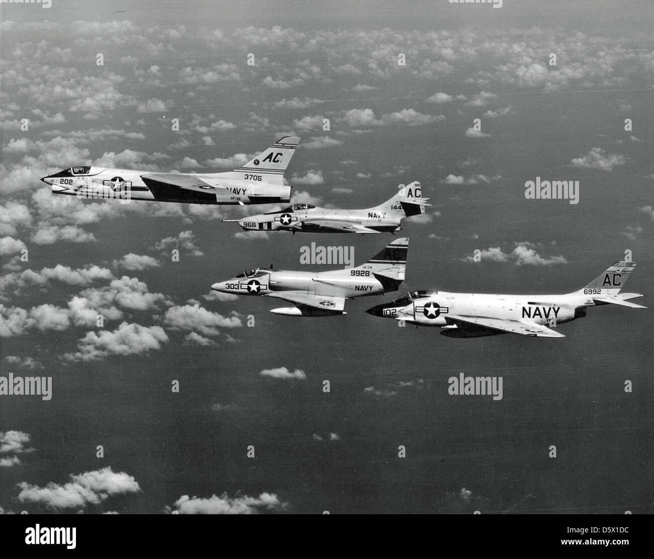 Les Vought F8U-1 'Crusader', McDonnell F3H-2M 'Demon', Grumman F9F-8P 'Cougar' et Douglas A4D-1 'Skyhawk' volent en formation au large de l'USS Saratoga (CVA-60) en 1957. Ces avions représentaient la pointe de l'aviation navale avec des rôles allant de chasseur aux missions de reconnaissance. Banque D'Images