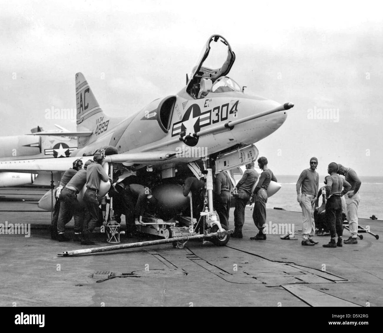 Le personnel charge un réservoir de carburant sur un Douglas A4D-2 'Skyhawk' de l'Attack Squadron (va) 34 sur le pont d'envol de l'USS Saratoga (CVA-60) lors d'une opération de 1959, présentant la maintenance des avions dans un environnement de porte-avions. Banque D'Images