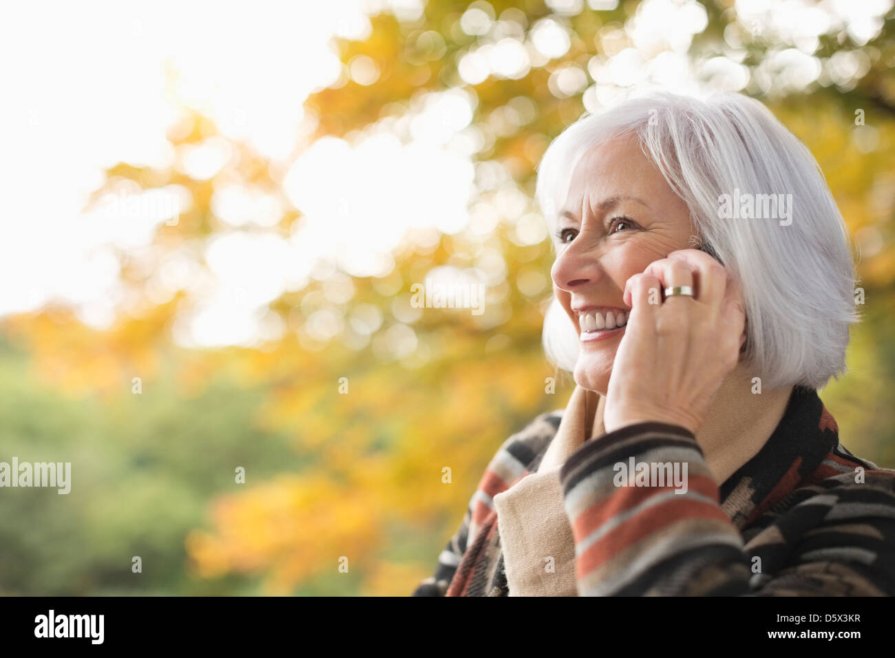 Older Woman talking on cell phone in park Banque D'Images