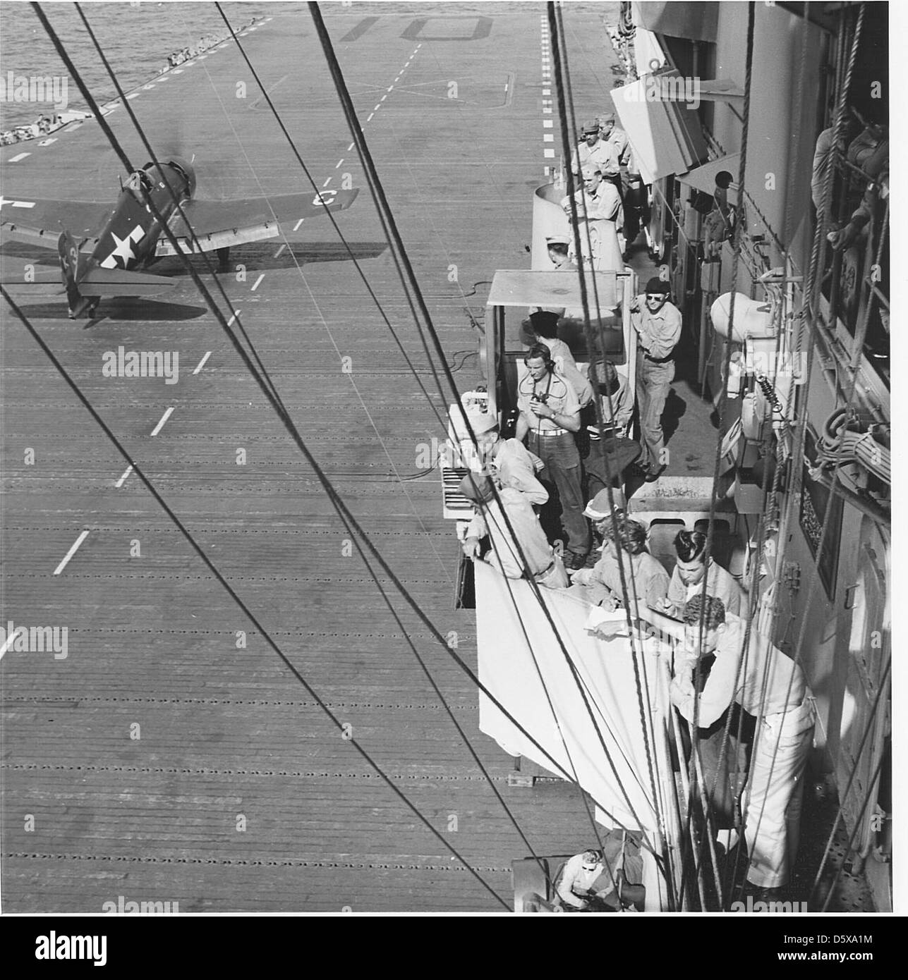 Le personnel à bord de l'USS Yorktown (CV-10) coordonne les opérations aériennes en tant que Grumman F6F-3 Hellcat du Fighter Squadron (VF) 1. Le Hellcat était un avion de chasse à porte-avions crucial sur le théâtre Pacifique pendant la IIe Guerre mondiale Banque D'Images