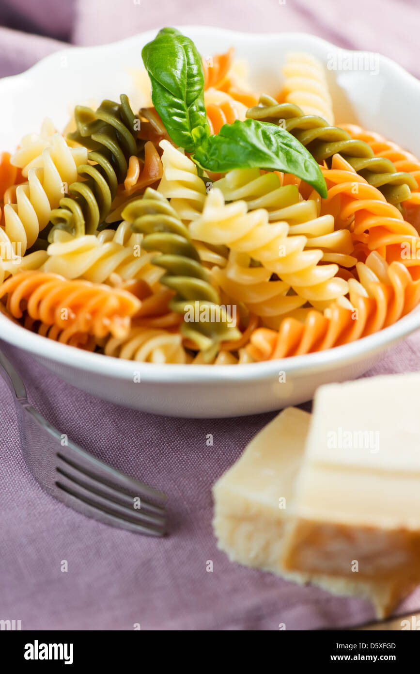 Les pâtes en spirale avec le fromage et le basilic sur table Banque D'Images