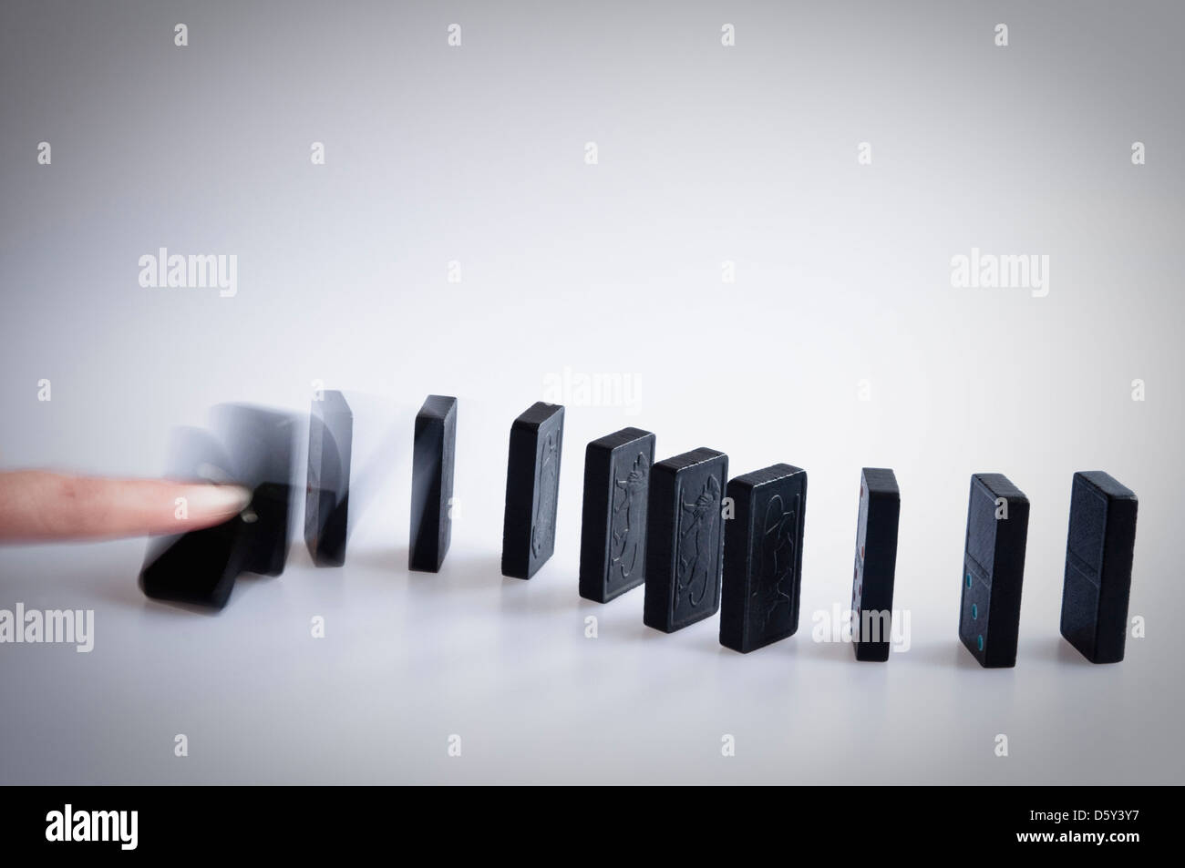 La chute des dominos - doigt poussant sur le premier domino et montrant le motion blur comme il tombe. Banque D'Images
