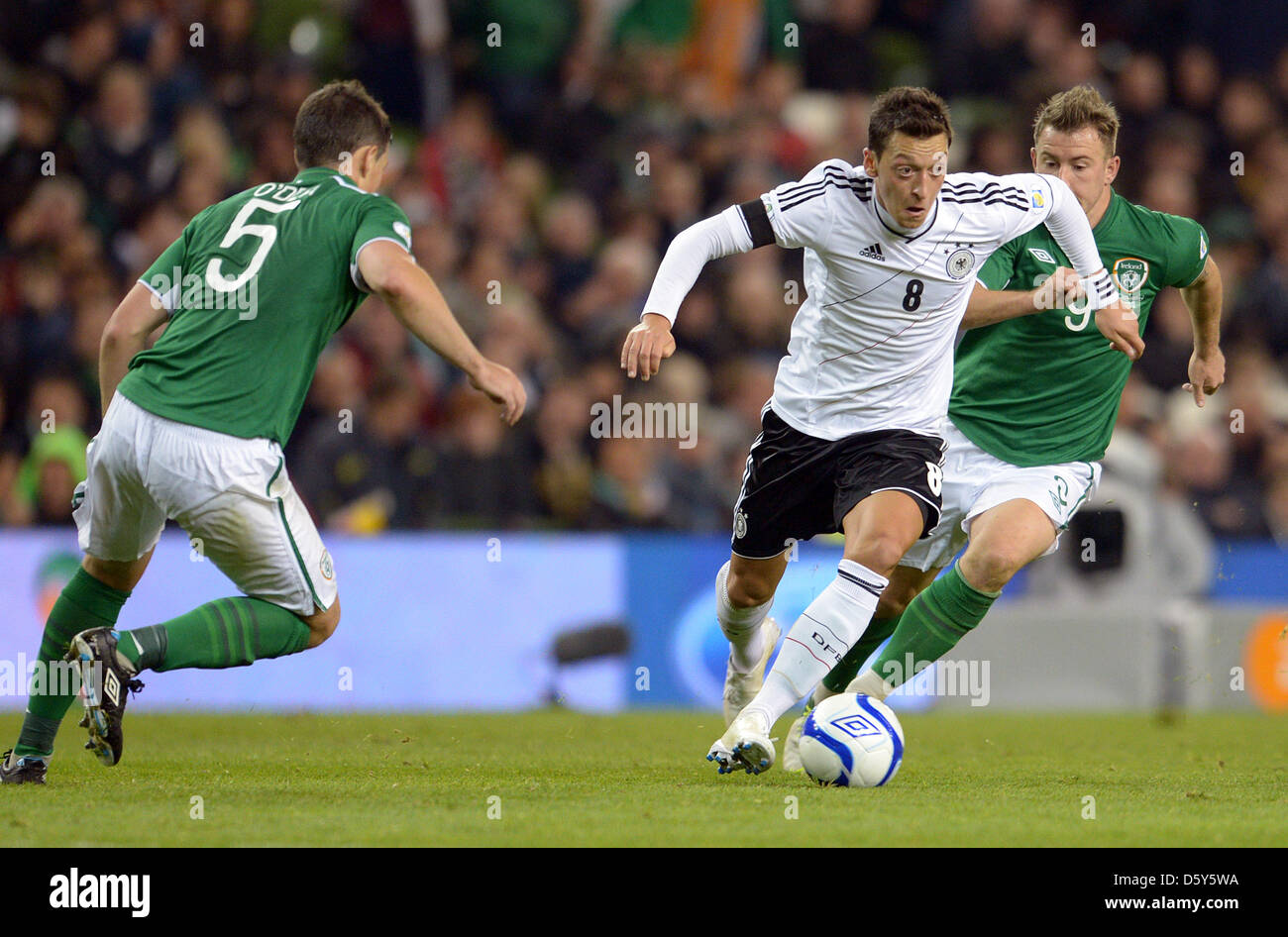 L'Allemagne Mesut Özil (c) convoite la la balle avec l'Irlande Simon Cox (r) et John O'Shea durant la Coupe du Monde FIFA 2014 football match de qualification entre l'Irlande et l'Allemagne à l'Aviva Stadium de Dublin, Irlande, 12 octobre 2012. Le jeu terminé 1:6. Photo : Federico Gambarini/dpa Banque D'Images