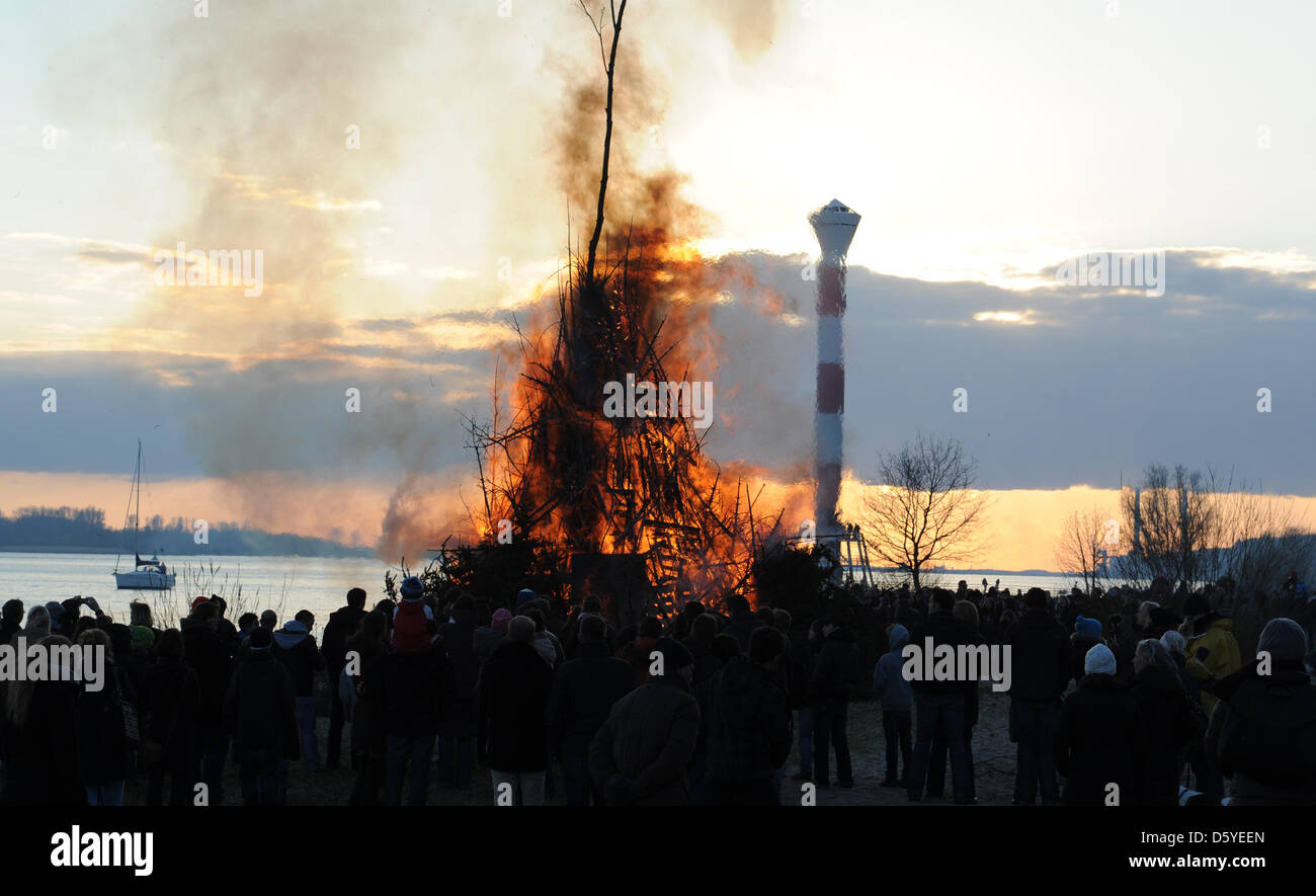 Les gens se tenir en face d'un feu traditionnel de Pâques à l'Elbe en Hamburg-Blankenese, Allemagne, 07 avril 2012. C'est la tradition d'allumer des feux en Allemagne dans la nuit avant le dimanche de Pâques. Photo : Angelika Warmuth Banque D'Images