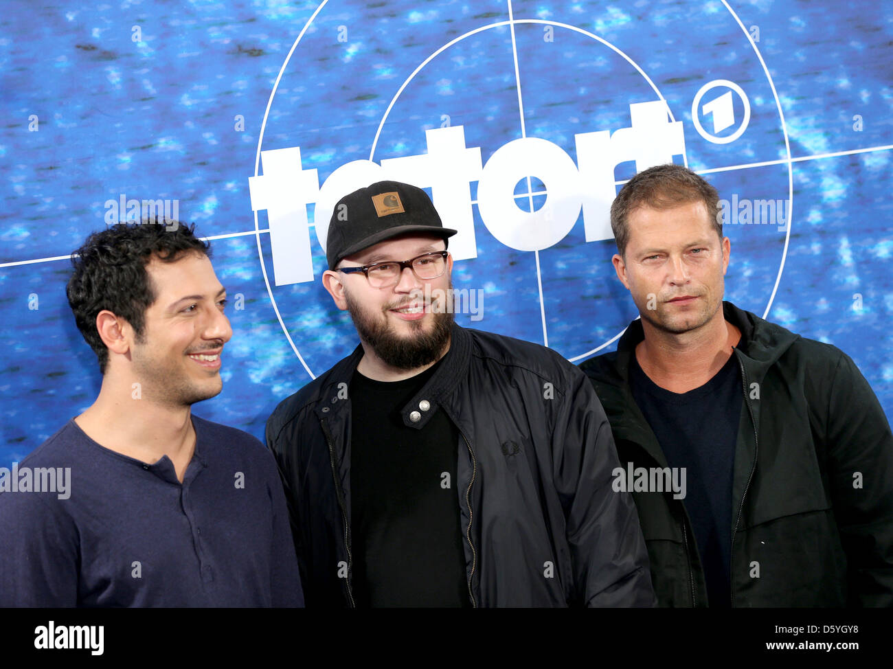 Til Schweiger acteurs (R), Fahrin Yardim (L) et réalisateur Christian Alvart pose devant l'appareil photo en face d'un logo de la série crime télévision allemande 'Tatort" (scène de crime) lors d'un photocall du radiodiffuseur Norddeutscher Rundfunk (NDR) lieu à un hôtel à Hambourg, Allemagne, 25 octobre 2012. Photo : Christian Charisius Banque D'Images