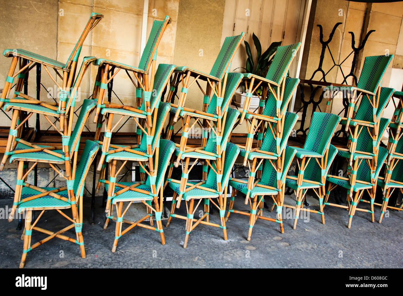 Chaises en osier disposés en piles avant la fermeture du café, Marais, Place des Vosges, Paris, France Banque D'Images