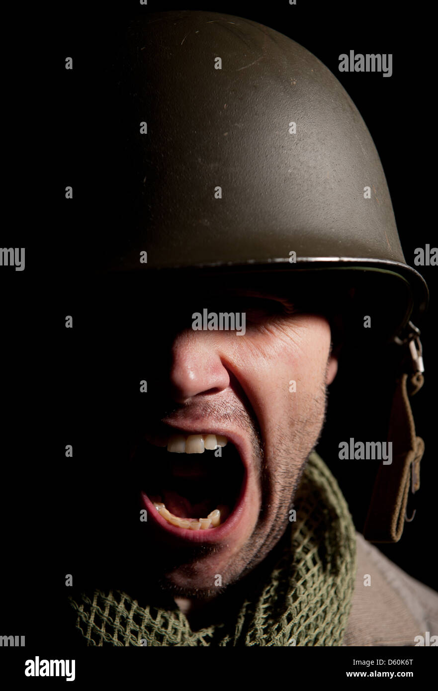 Portrait d'un soldat américain WW2 crier, avec des ombres profondes sur un fond noir. Banque D'Images