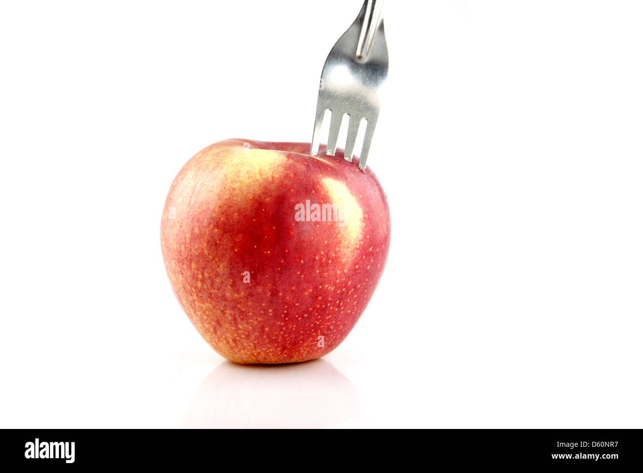 La Pomme Rouge sur le fond blanc, le Red Apple il y a une fourchette dans elle. Banque D'Images